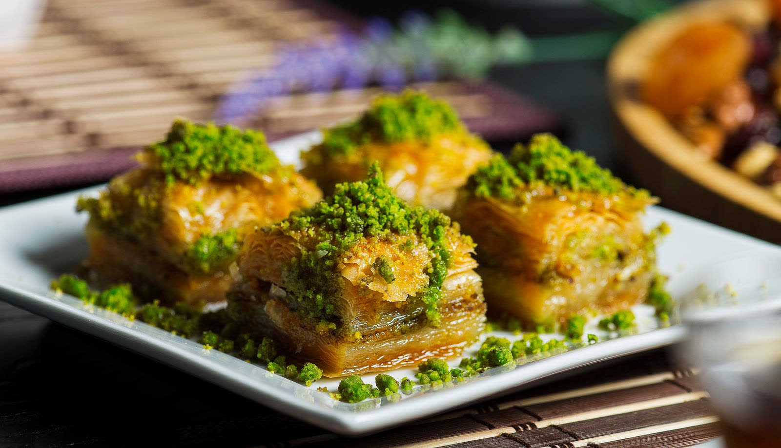 Vier stukken baklava met pistache op een wit bord (stockfoto).